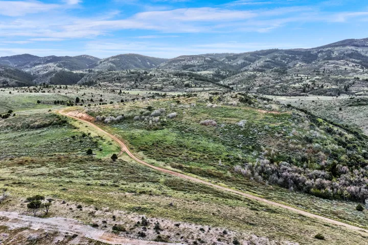 Expansive natural landscape featuring rolling hills and diverse vegetation