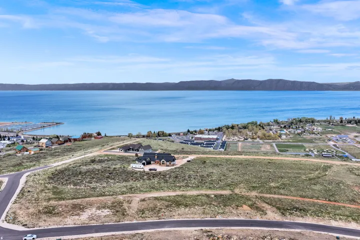 Expansive waterfront property with a residential structure, a private boat dock, and a mountainous backdrop