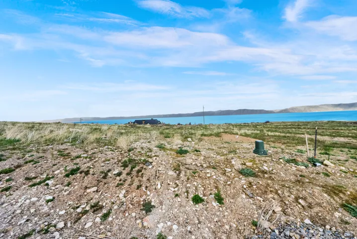 Expansive land parcel featuring natural terrain and a distant water body