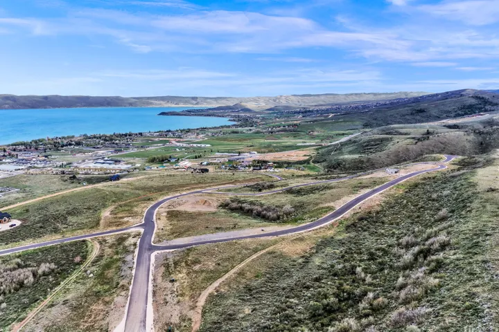 Expansive land parcel featuring paved roads, scattered residences, and mature vegetation