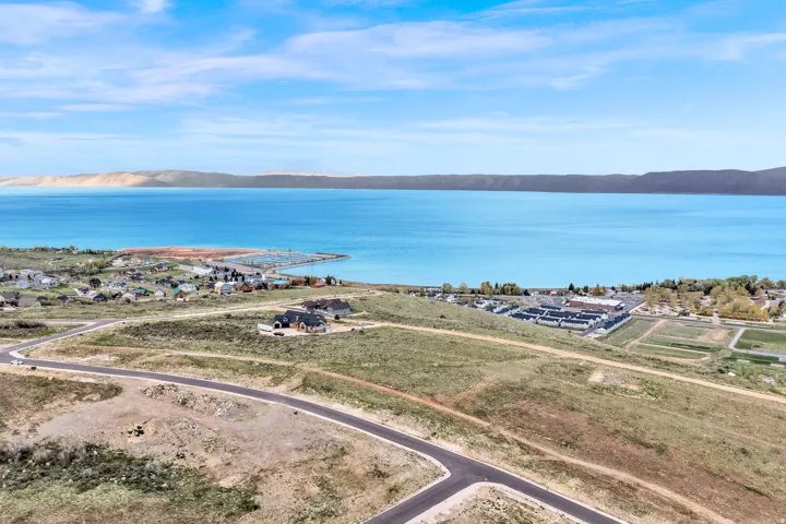 Expansive land parcel featuring paved roads, a gentle slope, and established homes