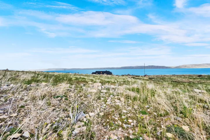 Expansive land parcel featuring natural grasses and scattered rock formations