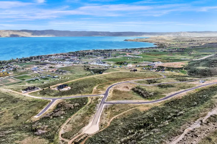 Expansive land parcel featuring new asphalt roads and a natural, undeveloped landscape with distant water views