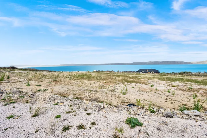 Expansive land parcel featuring natural terrain and a distant body of water
