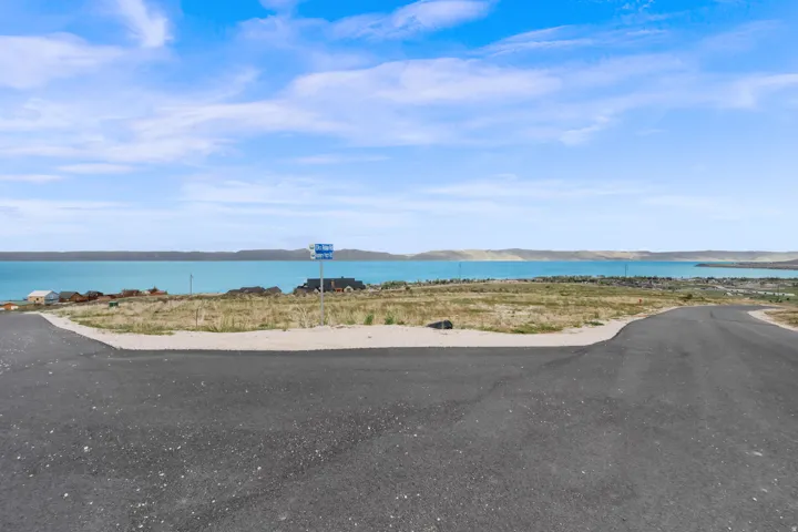 Paved road frontage with a water body backdrop
