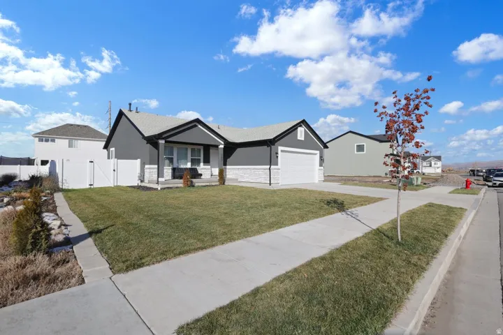 Single story home featuring a gate, stucco siding, a porch, driveway, and a residential view