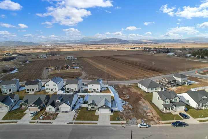 Overview of rural landscape featuring nearby suburban area and a mountainous background