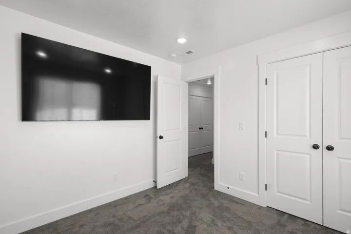 Unfurnished bedroom featuring dark colored carpet and a closet