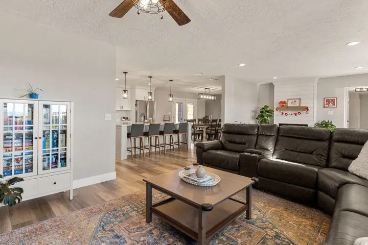 Living room with a textured ceiling, dark wood-style flooring, recessed lighting, and a ceiling fan