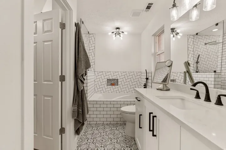 Bathroom featuring tiled tub, vanity, tiled shower, light tile patterned floors, and a textured ceiling
