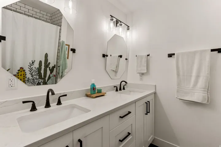 Full bath featuring double vanity and curtained shower