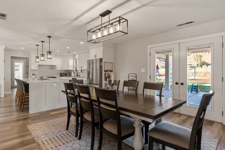 Dining area featuring french doors, light wood finished floors, recessed lighting, and a textured ceiling