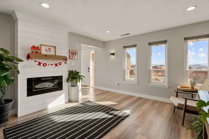 Unfurnished living room with light wood finished floors, a large fireplace, recessed lighting, and a textured ceiling