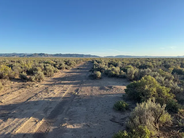 View of dirt / gravel road featuring a mountain view and a view of rural / pastoral area