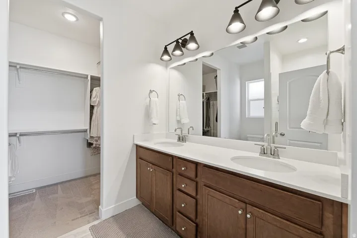 Full bath with a walk in closet, double vanity, and recessed lighting