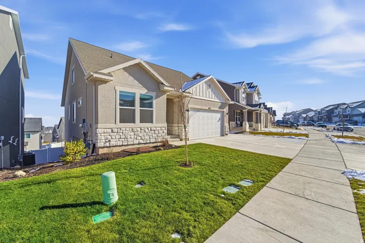 Craftsman inspired home with a residential view, stone siding, driveway, stucco siding, and an attached garage