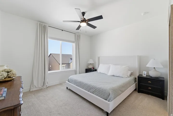 Bedroom featuring light colored carpet and ceiling fan