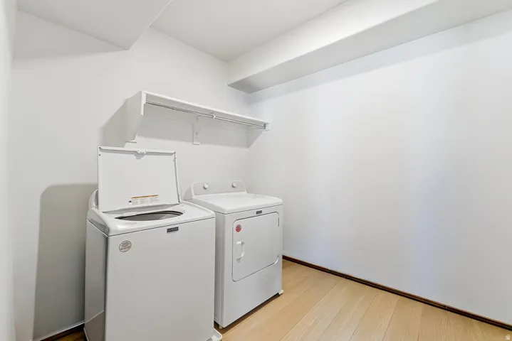 Laundry area featuring light wood-style floors and washer and clothes dryer