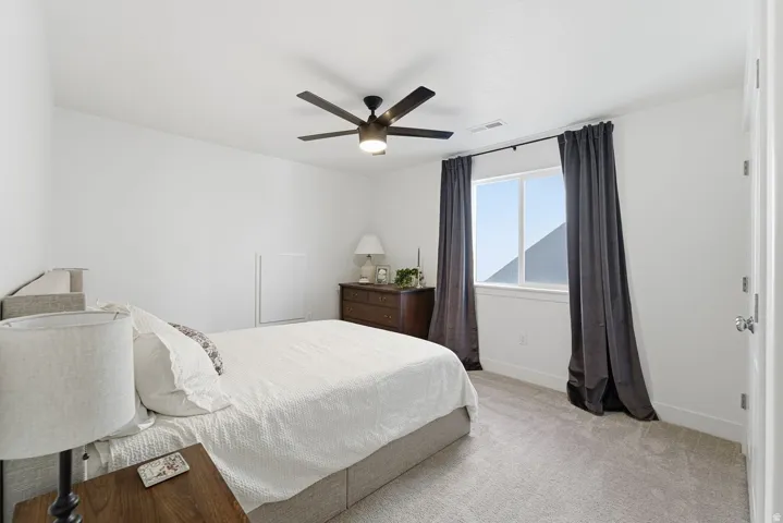 Bedroom featuring light colored carpet and ceiling fan