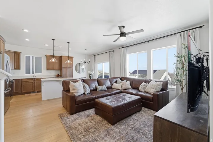 Living area featuring recessed lighting, light wood-type flooring, a chandelier, and a ceiling fan