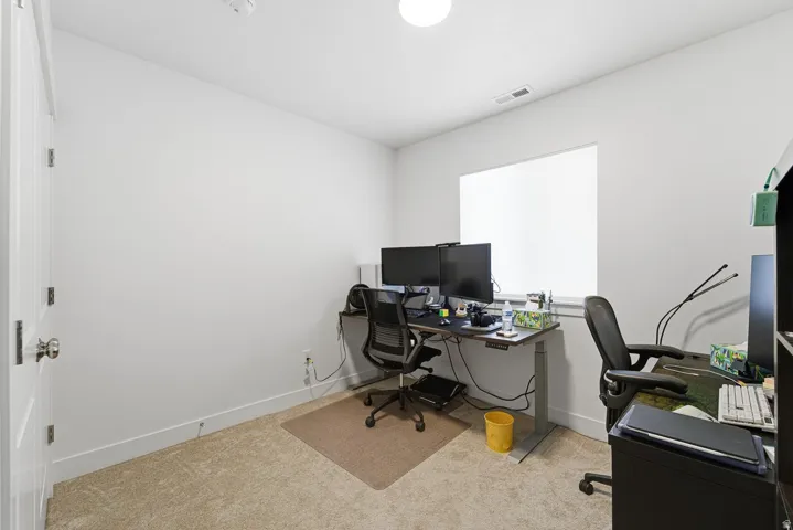 Home office featuring baseboards and light carpet