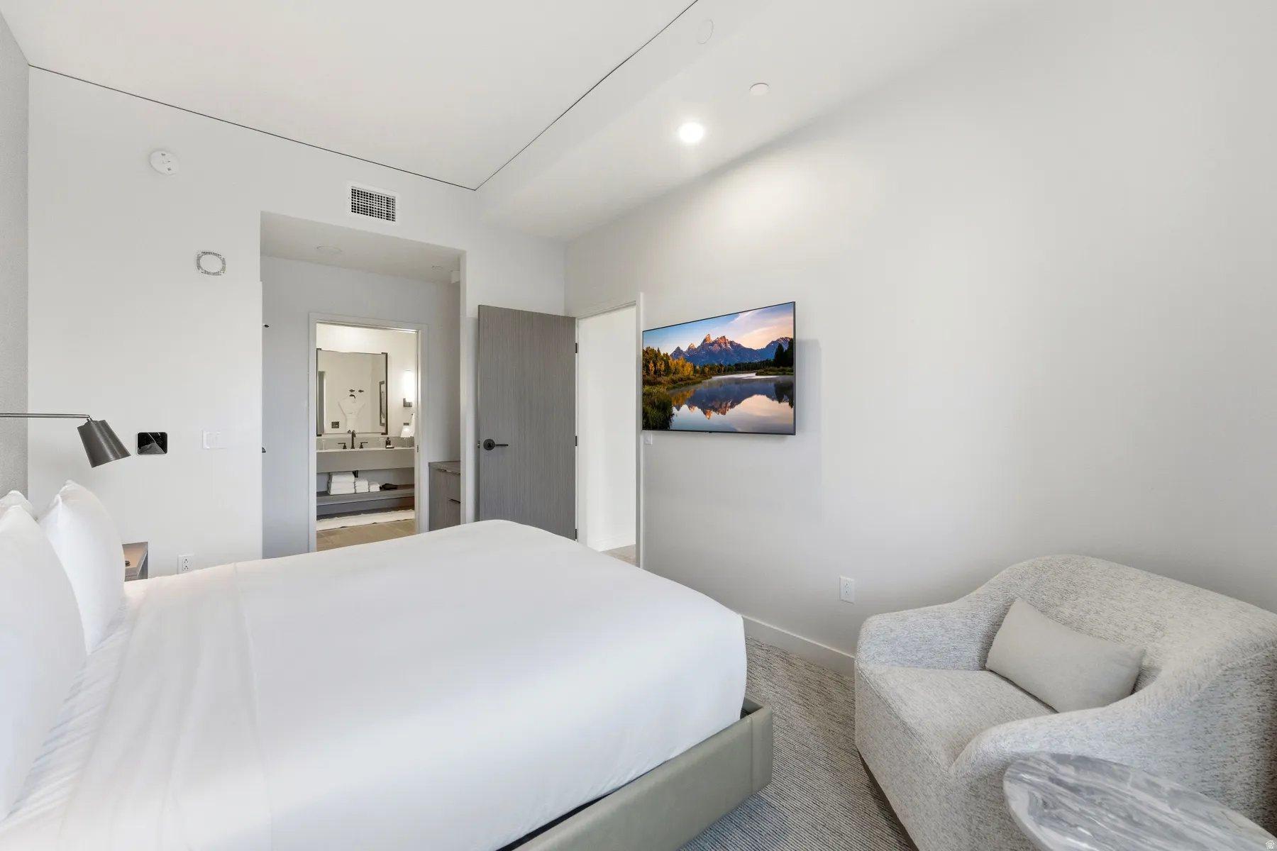 Bedroom featuring ensuite bathroom and carpet