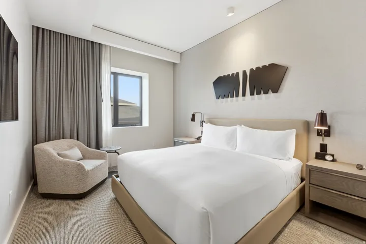 Bedroom with light colored carpet and baseboards