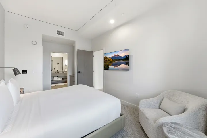 Bedroom featuring ensuite bathroom and carpet