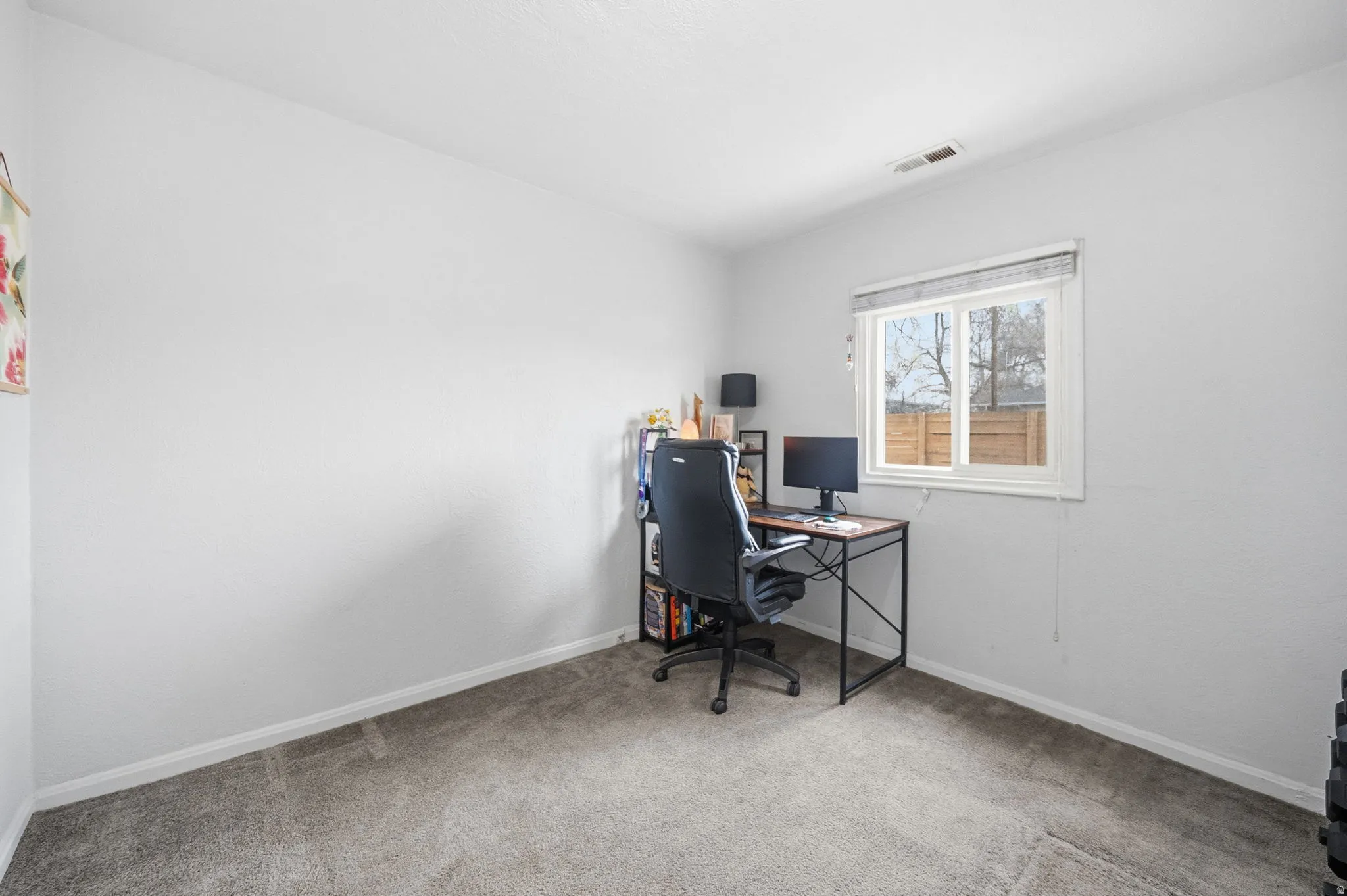 Home office featuring light carpet and baseboards