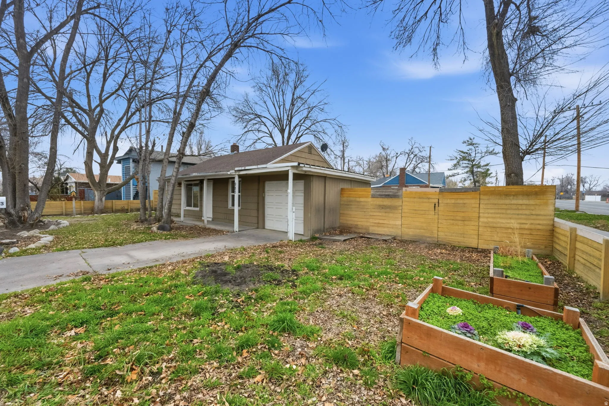 View of front facade with concrete driveway, a garden, and a garage