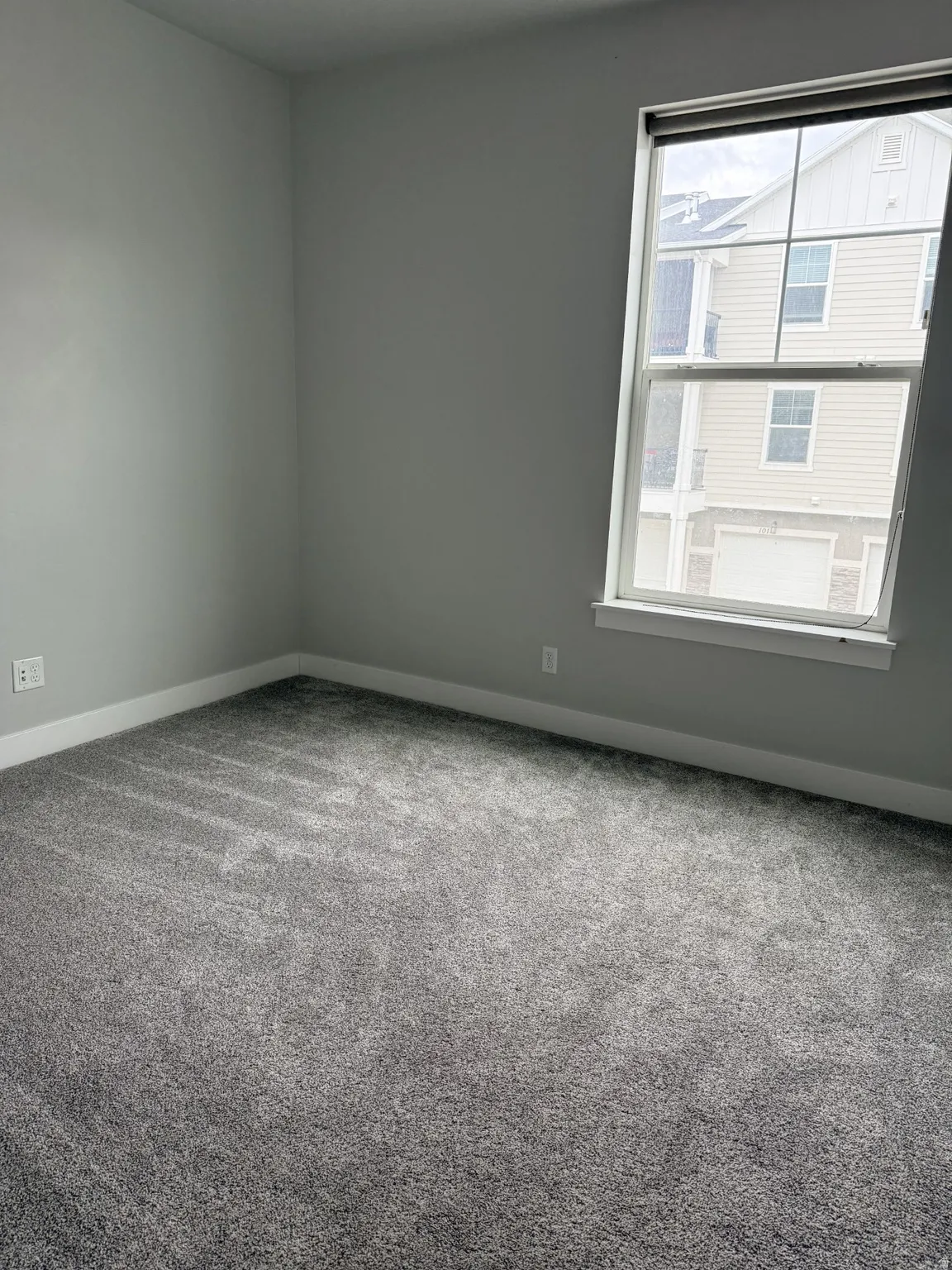 Carpeted empty room with baseboards