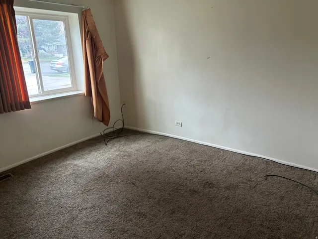 Spare room featuring carpet and baseboards