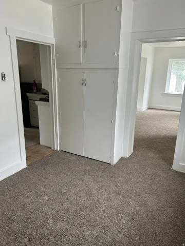 Unfurnished bedroom featuring light carpet and a closet
