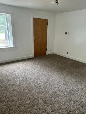 Carpeted empty room featuring baseboards