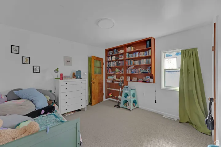 Bedroom with light carpet and baseboards