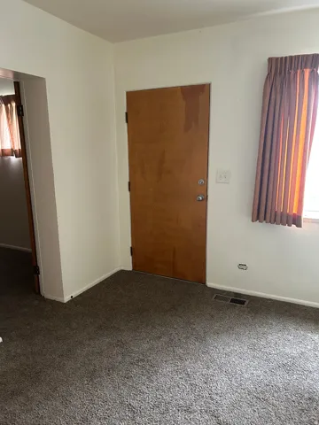 Carpeted spare room with baseboards