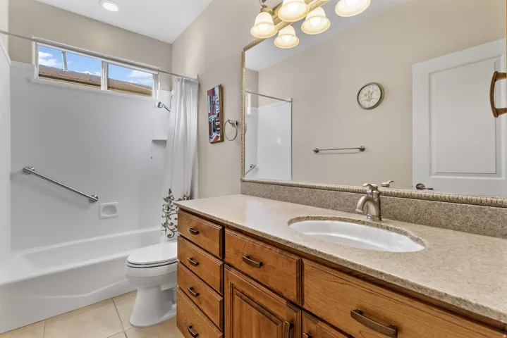 Maind bathroom featuring vanity, shower / bath combo, and light tile patterned flooring