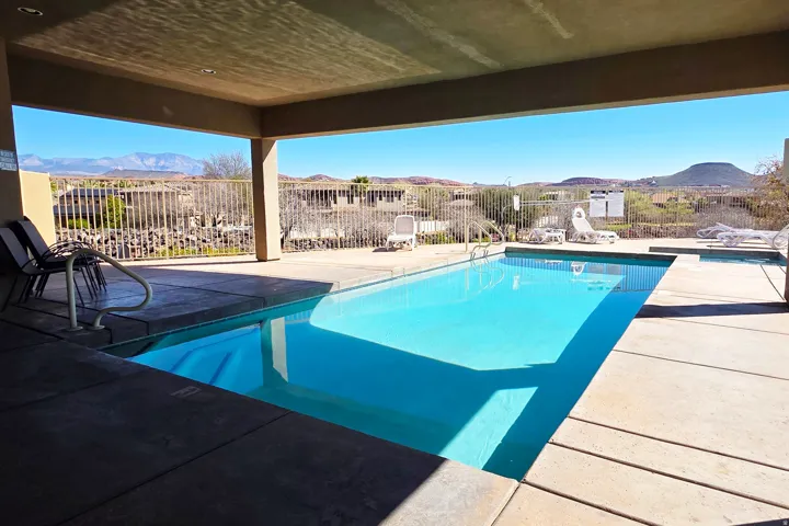 View of pool with patio surround, a mountain view, and a fenced backyard