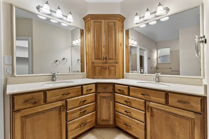 Primary bathroom with double vanity and light tile patterned flooring