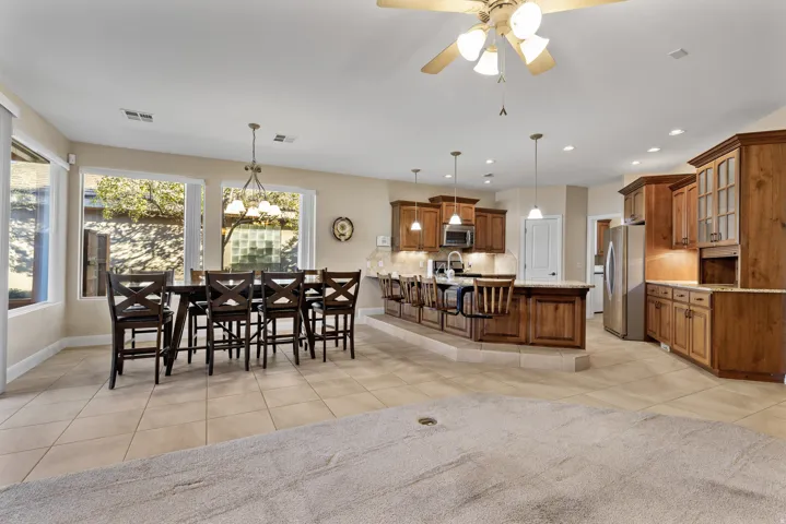 Dining space featuring light tile patterned floors, a chandelier, ceiling fan, and recessed lighting