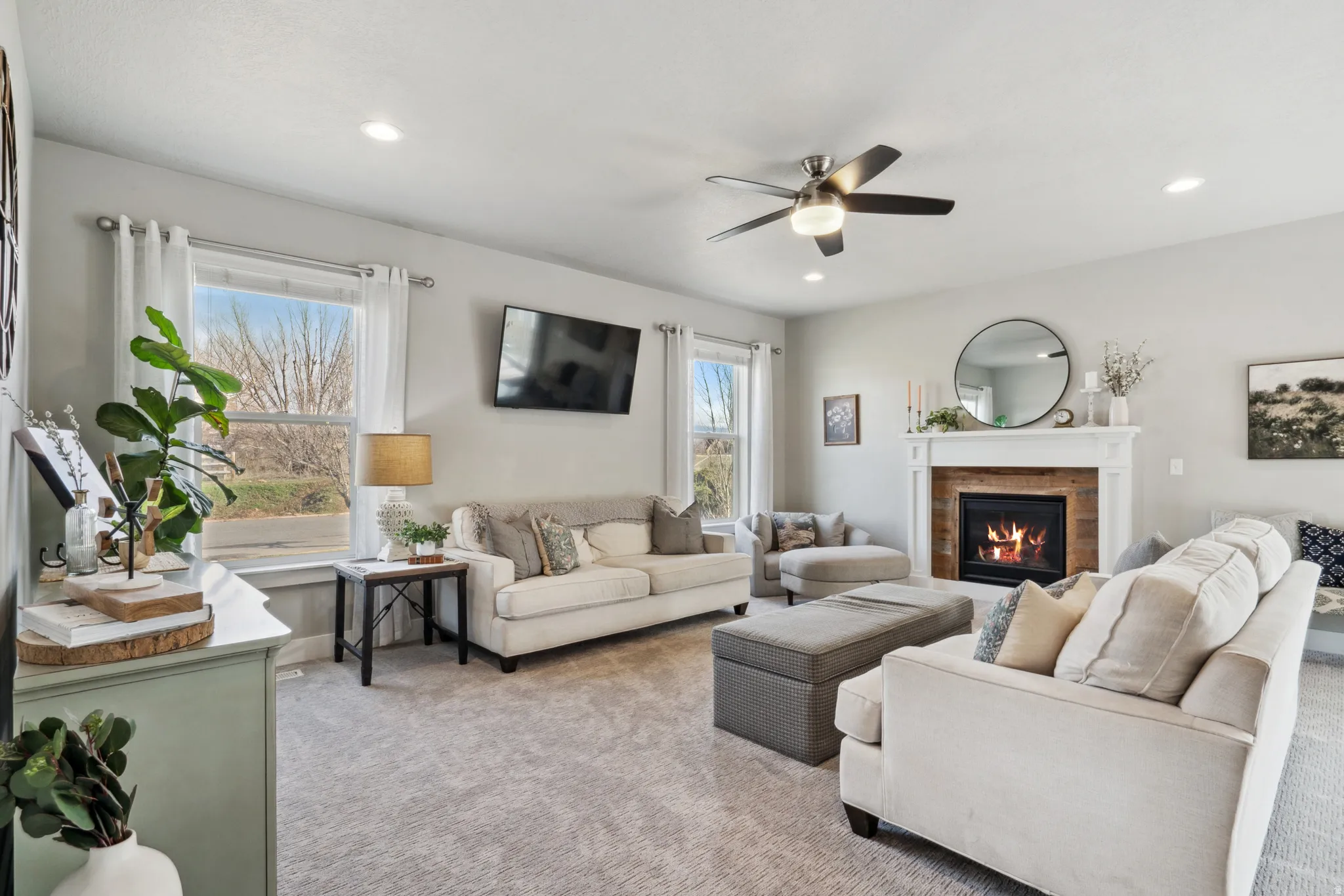 Living area featuring carpet flooring, a fireplace, ceiling fan, and recessed lighting