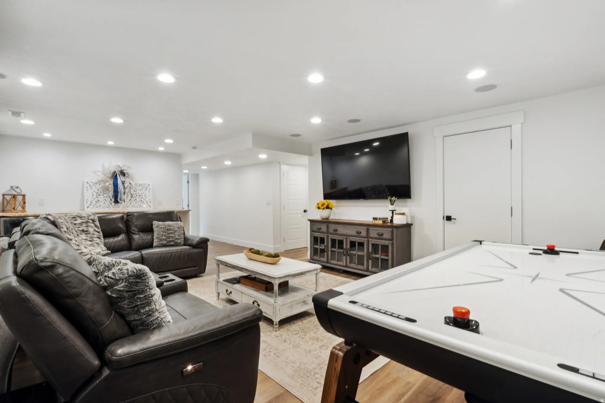 Downstairs living/rec room featuring light wood-type flooring and recessed lighting