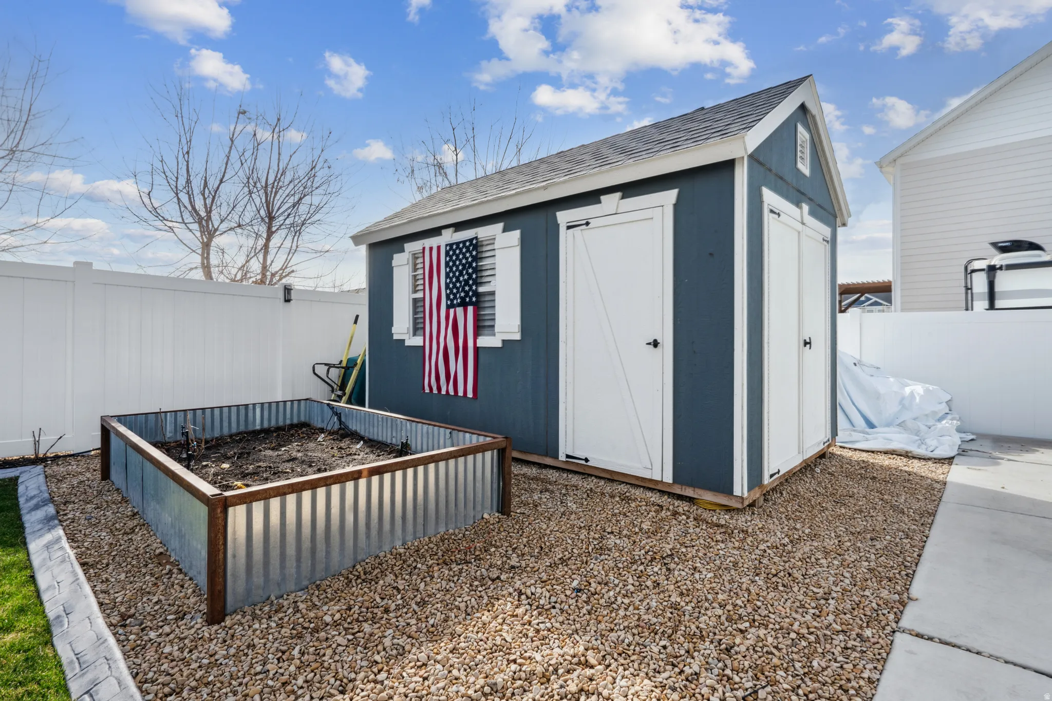View of shed with a vegetable garden and a fenced backyard