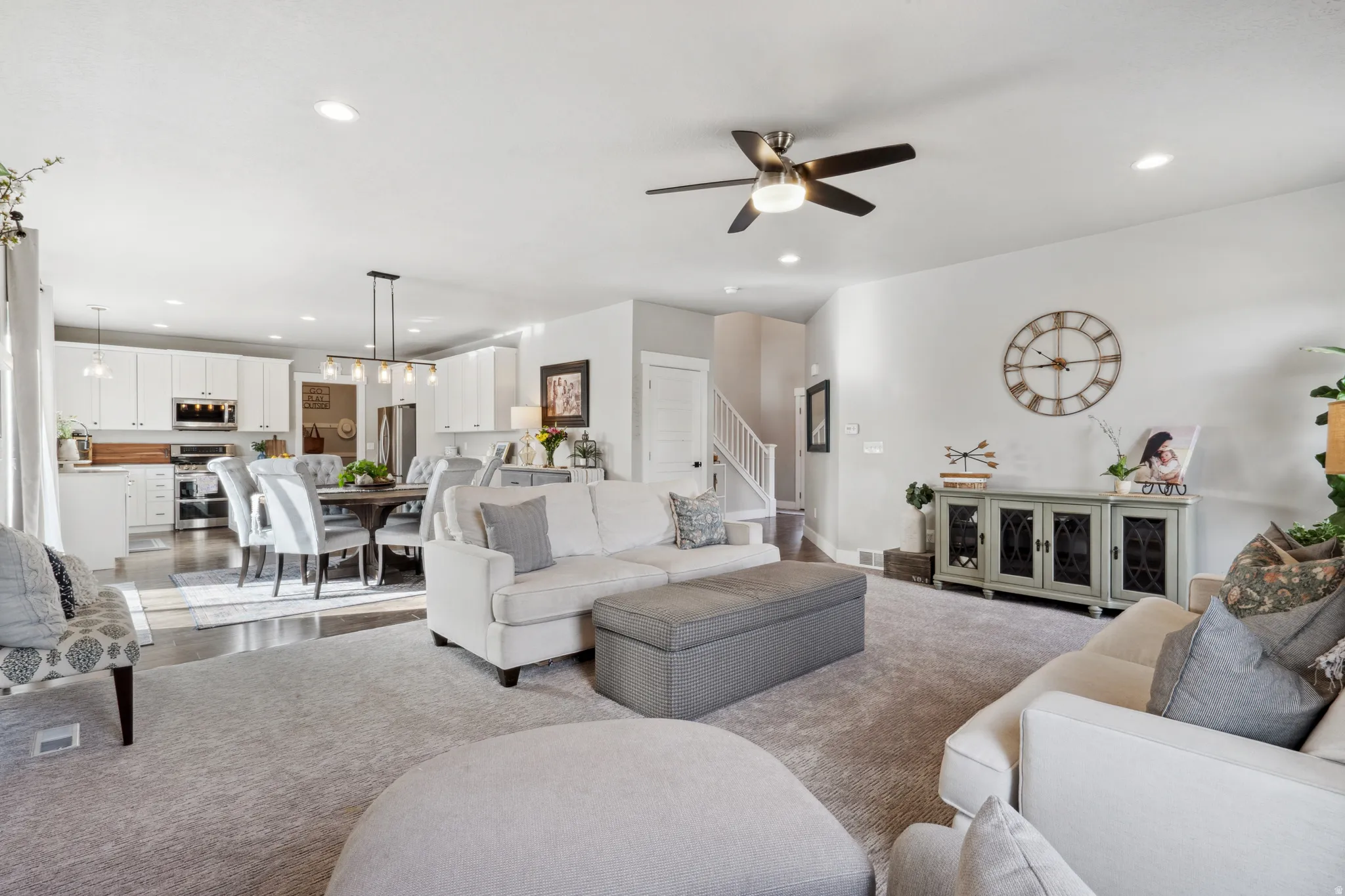 Living room with recessed lighting, a ceiling fan, carpet flooring, and stairway