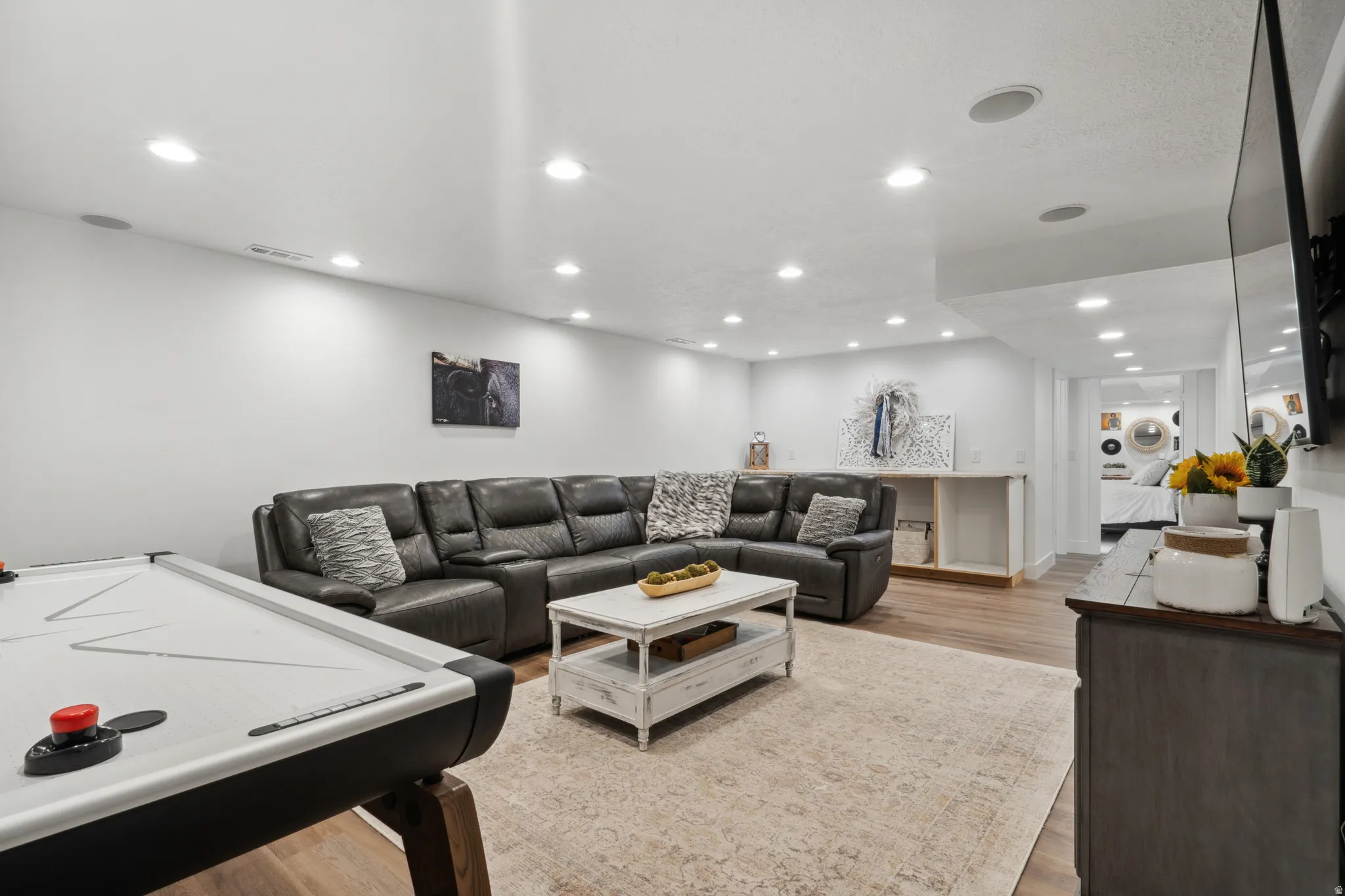 Downstairs living area featuring light wood-style floors and recessed lighting