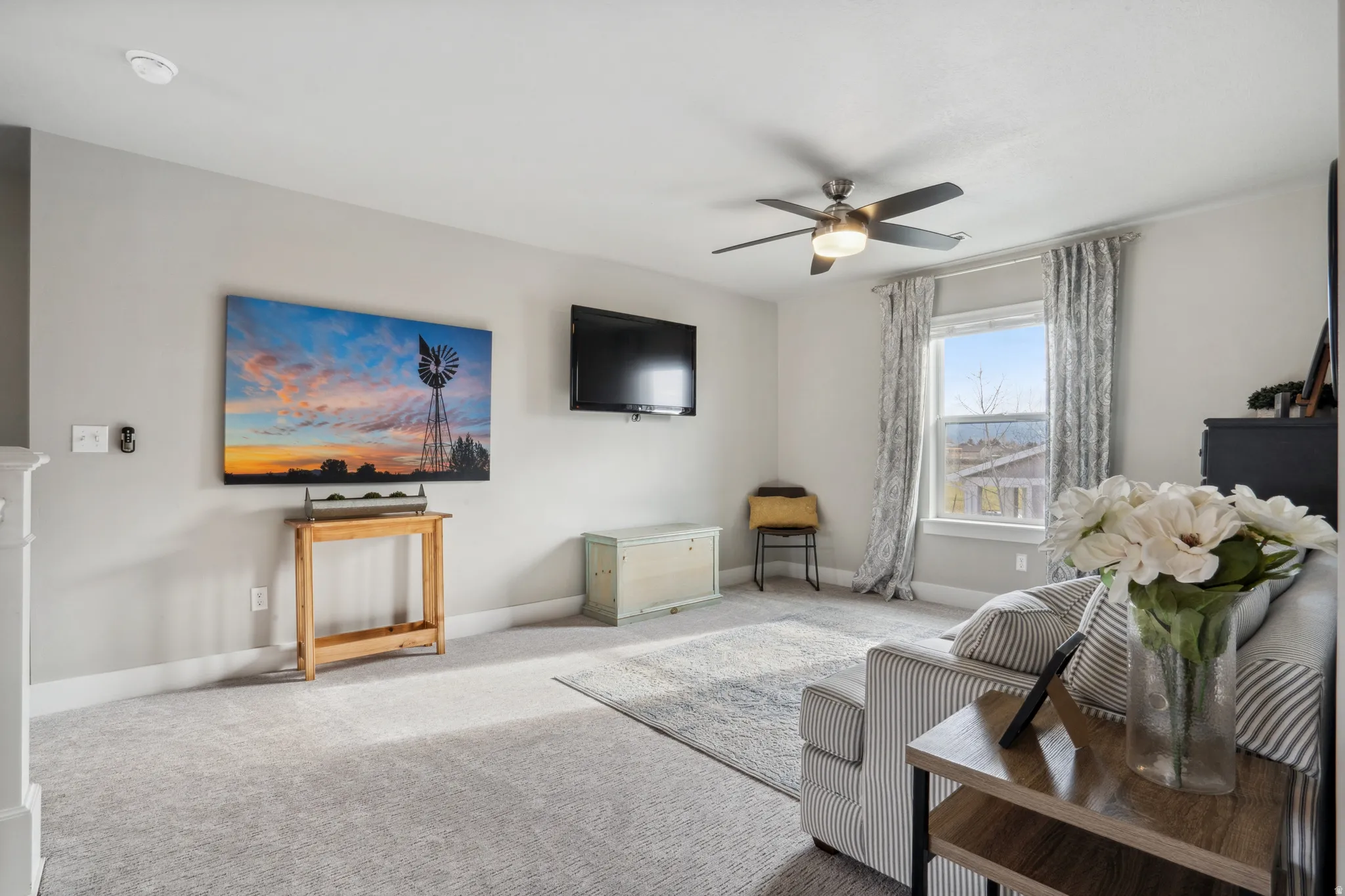 Upstairs arpeted living room with baseboards and a ceiling fan