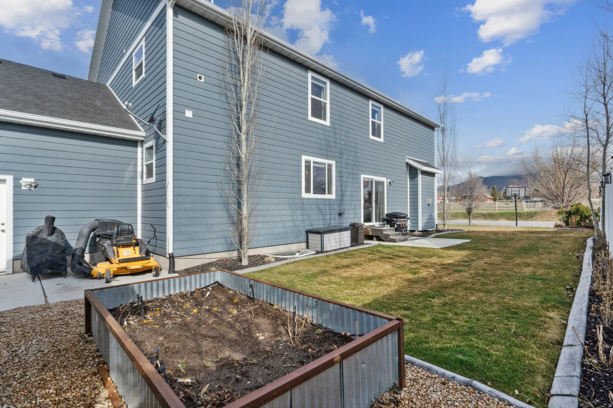 Rear view of property featuring a garden and a patio area