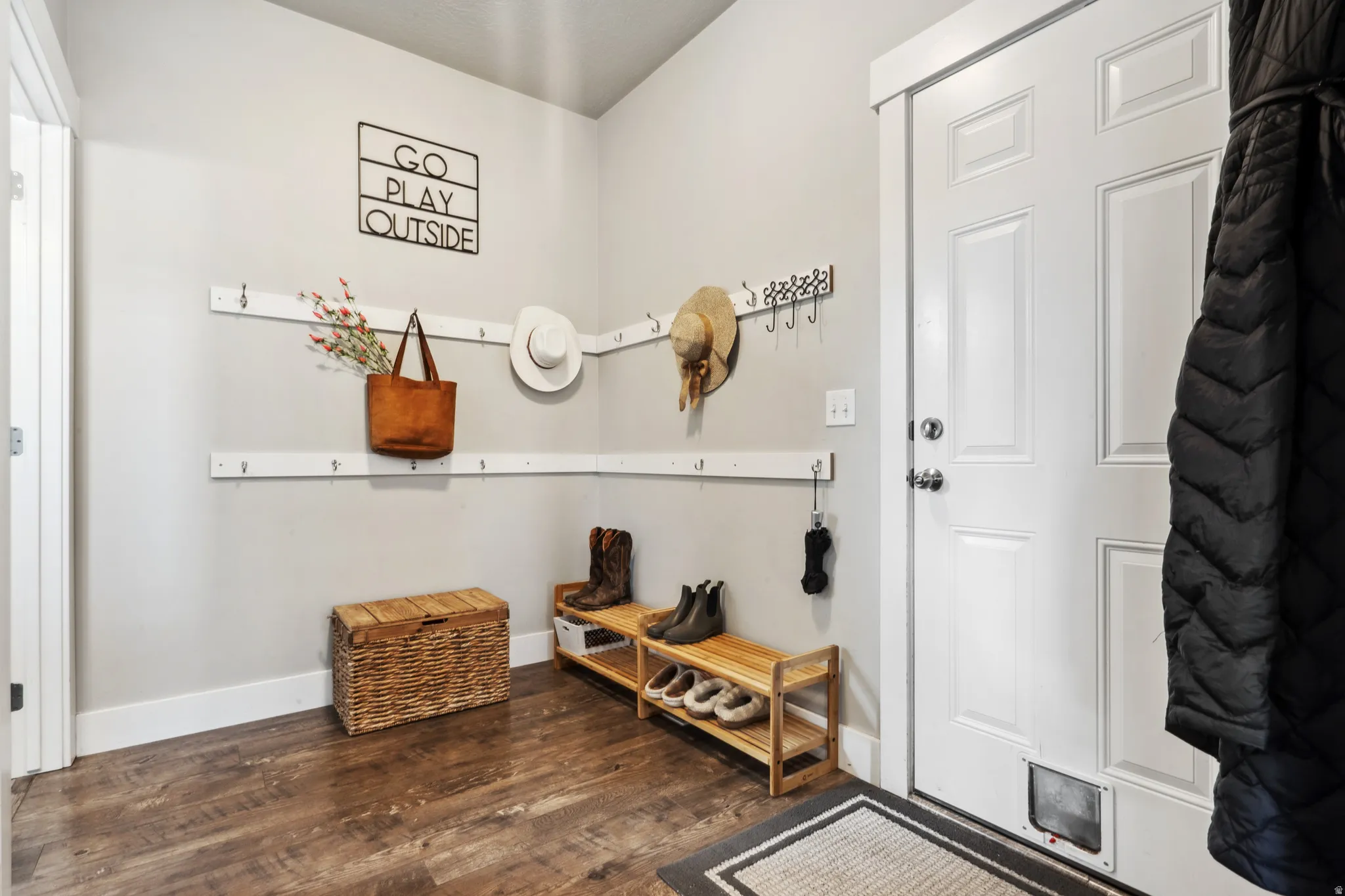 Mudroom featuring dark wood finished floors and baseboards