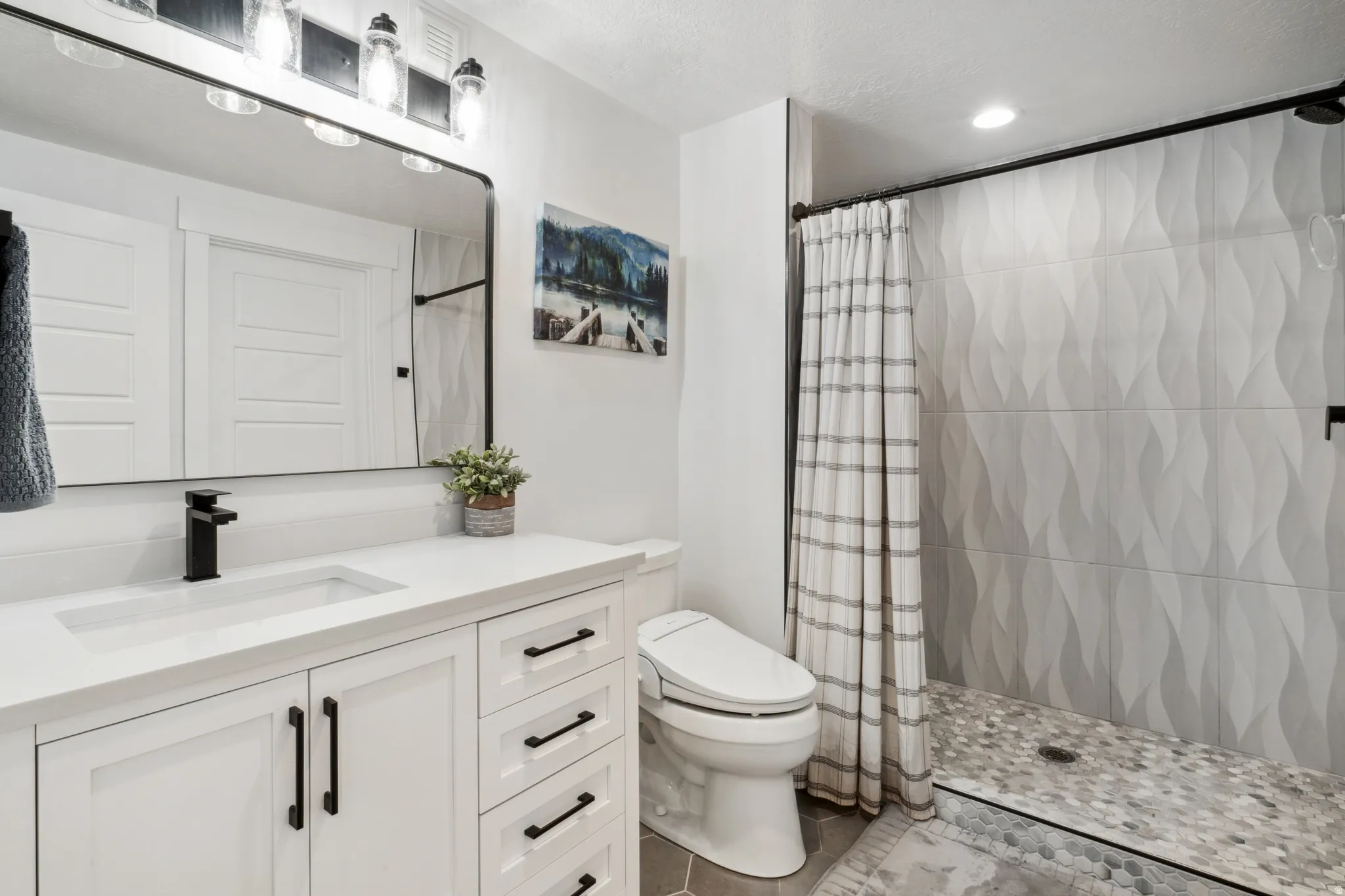 Bathroom featuring a tile shower, vanity, recessed lighting, a textured ceiling, and tile patterned flooring