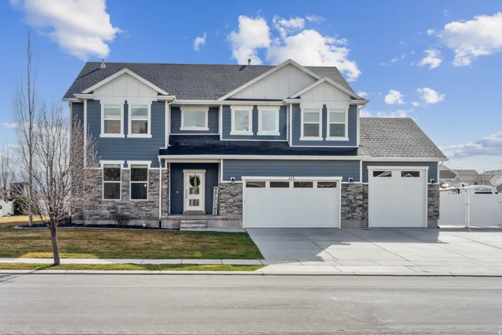 Craftsman-style house with board and batten siding, concrete driveway, and stone siding